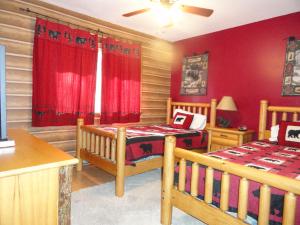 a bedroom with two twin beds and red walls at Maple Chalet by VCI Real Estate Services in Beech Mountain