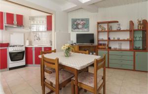 a kitchen with a table with a vase of flowers on it at Beautiful Apartment In Kastel Kambelovac With 2 Bedrooms And Wifi in Kaštela
