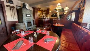 un restaurante con mesa, sillas y chimenea en Hôtel Restaurant Lamy, en Troisvierges