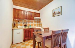 La cuisine est équipée d'une table, de chaises et d'un réfrigérateur. dans l'établissement Amazing Apartment In Susak With Wifi, à Susak