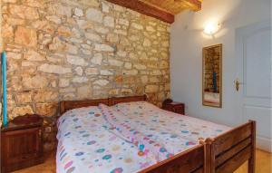 Ce lit se trouve dans un dortoir doté d'un mur en pierre. dans l'établissement Amazing Apartment In Susak With Wifi, à Susak