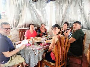 grupa ludzi siedzących przy stole jedzących jedzenie w obiekcie Gloriya Mathews w Negombo