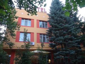 un edificio con dos árboles delante de él en Family Hotel Familya en Ruse