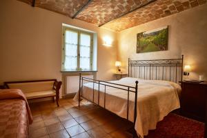ein Schlafzimmer mit einem Bett, einem Fenster und einem Sofa in der Unterkunft Agriturismo Podere La Piazza in Costigliole dʼAsti