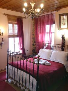 a bedroom with a bed with pink curtains and a chandelier at Siatistino Archontariki in Siátista