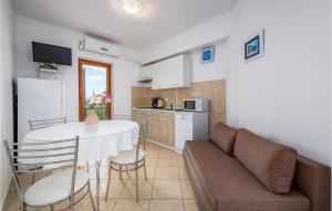 2 Bedroom Beautiful Apartment In Labin في Drenje: مطبخ وغرفة معيشة مع طاولة وأريكة