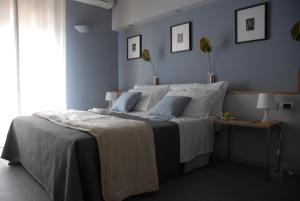 a bedroom with a large bed with blue walls at B&B Habita in Modica