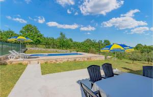 a patio with two umbrellas and a swimming pool at Beautiful Home In Zminj With Kitchen in Žminj