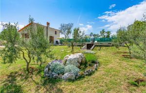 a yard with a house and a garden with trees at Beautiful Home In Zminj With Kitchen in Žminj