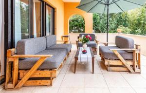 eine Terrasse mit 2 Sofas, einem Tisch und einem Sonnenschirm in der Unterkunft Lovely Apartment In Fazana With Wifi in Fažana