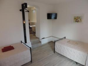 Habitación con 2 camas y TV en la pared. en Guesthouse Nikola, en Lagos de Plitvice