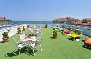 un patio con tavoli e sedie sul tetto di Hotel Ciondolo D'Oro a Rimini
