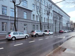 a row of cars parked on the side of a street at Owl Jazz Apartments - luxury apartments in the heart of the city in Kaunas