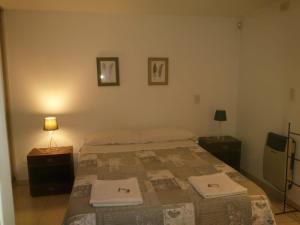 1 dormitorio con 1 cama con 2 toallas en Departamentos modo turista en Tunuyán