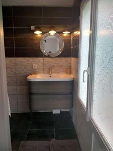 La salle de bains est pourvue d'un lavabo et d'un miroir. dans l'établissement Côté Mer - Jardin privatif à 200m de la plage, à Ver-sur-Mer