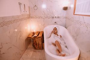 Inkasaire Boutique Lodge في أوروبامبا: امرأة جالسة في حوض الاستحمام في الحمام