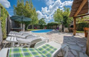 un grupo de sillas y una sombrilla junto a una piscina en Stunning Home In Pazin With Wifi, en Heki