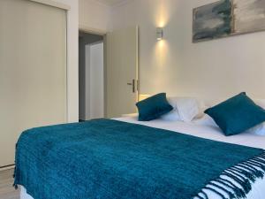 a bedroom with a large bed with a blue blanket at T1 center of Marina Vilamoura in Quarteira