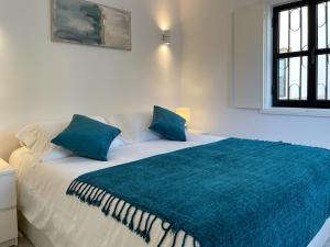 a white bed with blue pillows in a room at T1 center of Marina Vilamoura in Quarteira +4 photos