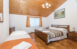 a bedroom with two beds and a wooden ceiling at Stunning Apartment In Brsec in Brseč