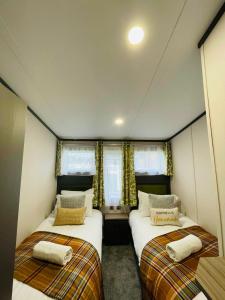 a room with two beds in a room at Happy Days Lodge with Hot Tub in York +14 photos