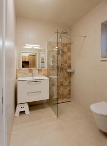La salle de bains est pourvue d'une douche, d'un lavabo et de toilettes. dans l'établissement Gästehaus - Boardinghouse Magnetsried, à Seeshaupt