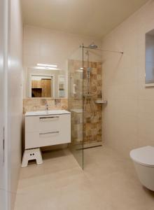 ein Badezimmer mit Dusche, Waschbecken und Toilette in der Unterkunft Gästehaus - Boardinghouse Magnetsried in Seeshaupt