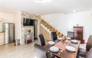 une salle à manger avec une table, des chaises et un escalier dans l'établissement Beautiful Home In Pomer With Wifi, à Pomer