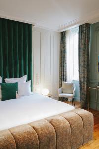 a hotel room with a bed, chair, and nightstand at Hôtel Singulier Bordeaux in Bordeaux