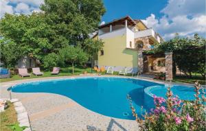 a swimming pool in front of a house at 2 Bedroom Nice Apartment In Veli Jezenj in Veli Ježenj