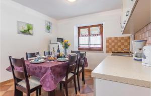 a kitchen with a table with a purple table cloth at 2 Bedroom Nice Apartment In Veli Jezenj in Veli Ježenj