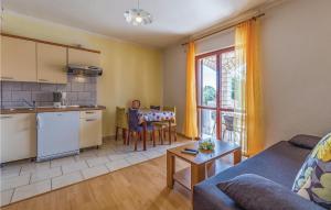 a kitchen and living room with a couch and a table at Stunning Apartment In Medulin With Wifi in Medulin