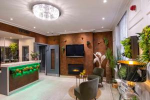 ein Wohnzimmer mit einem Kamin und einem TV in der Unterkunft Howard Winchester Hotel in London