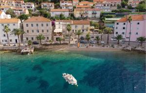 a small boat in the water near a beach at Gorgeous Apartment In Prizba With House Sea View in Prizba