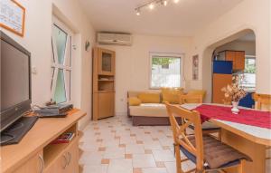 ein Wohnzimmer mit einem TV und einem Esszimmer in der Unterkunft Awesome Apartment In Donji Karin With Kitchen in Donji Karin