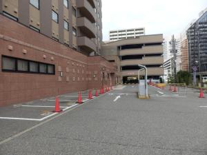 un parcheggio vuoto con coni arancioni di fronte a un edificio di Hotel Route-Inn Kanazawa Ekimae a Kanazawa