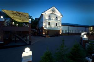 a large white building with a lit up courtyard at Metelitsa Hotel in Krasnoyarsk