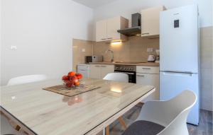 a kitchen with a table with a bowl of fruit on it at Lovely Apartment In Podstrana With Wifi in Sveti Martin