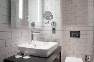 ein weißes Badezimmer mit einem Waschbecken und einem Spiegel in der Unterkunft Holiday Inn Bolton Centre, an IHG Hotel in Bolton