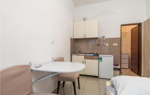 una piccola cucina con tavolo bianco e frigorifero di Cozy Apartment In Sveti Juraj With Wifi a Sveti Juraj