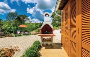 mały dom z małym piekarnikiem na dziedzińcu w obiekcie One-Bedroom Holiday Home In Bartici w mieście Barbići