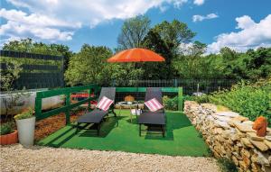 taras ze stołem, krzesłami i parasolem w obiekcie One-Bedroom Holiday Home In Bartici w mieście Barbići