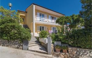 a large yellow house with a stone wall at Amazing Apartment In Rabac With Wifi in Raša