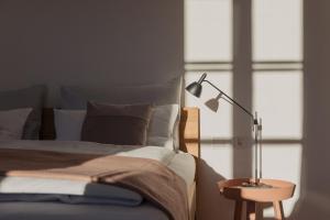 een slaapkamer met een bed met een lamp op een tafel bij Marktbar Studios - Boutique Aparthotel in Innsbruck