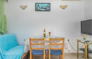 a dining room table with two chairs and a tv at 1 Bedroom Amazing Apartment In Mali Losinj in Mali Lošinj