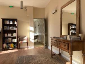 ein Badezimmer mit einer Kommode, einem Spiegel und einem Stuhl in der Unterkunft Hotel Mona Lisa in La Baule