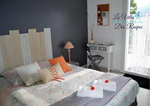 a bedroom with a bed with towels and a desk at La Villa Des Raspes - Holistique Spa - Adult Only in Viala-du-Tarn
