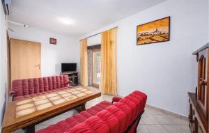 een wachtkamer met rode stoelen en een tafel bij 2 Bedroom Gorgeous Home In Marcenagla in Marčenigla