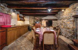 eine Küche mit einem Tisch mit Stühlen und einem Kamin in der Unterkunft 2 Bedroom Gorgeous Home In Marcenagla in Marčenegla