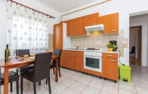 a kitchen with a table and a dining room at 1 Bedroom Cozy Apartment In Kostrena in Kostrena